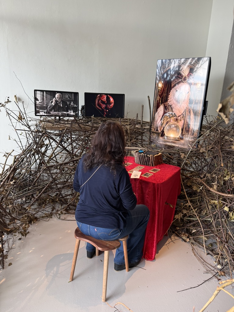 Visitor seated at the red table in front of the cockatoo fortune teller.