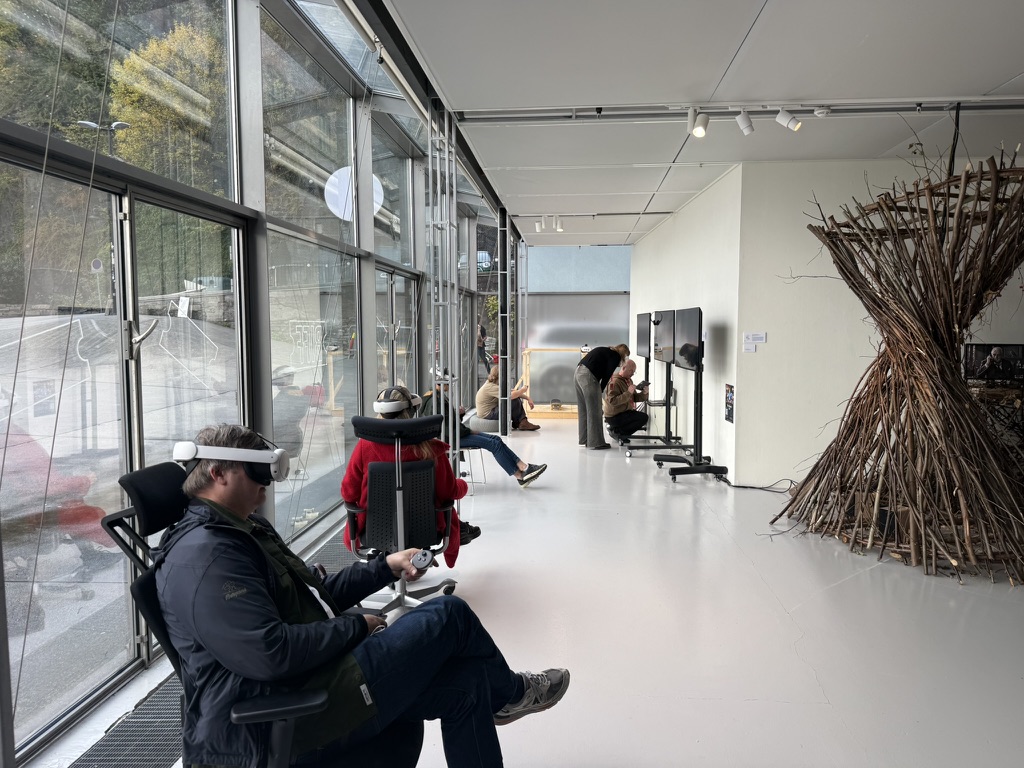 Viewers wearing VR headsets interact with The Grand Hotel Galactic Center at the After Virtual Reality exhibition in Bergen, with the Bald Cockatoo installation visible at right.