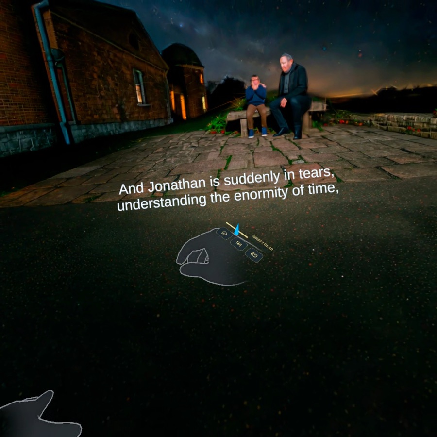 Jonathan and another man sit on a stone terrace beneath the night sky as virtual hands hover in the foreground.