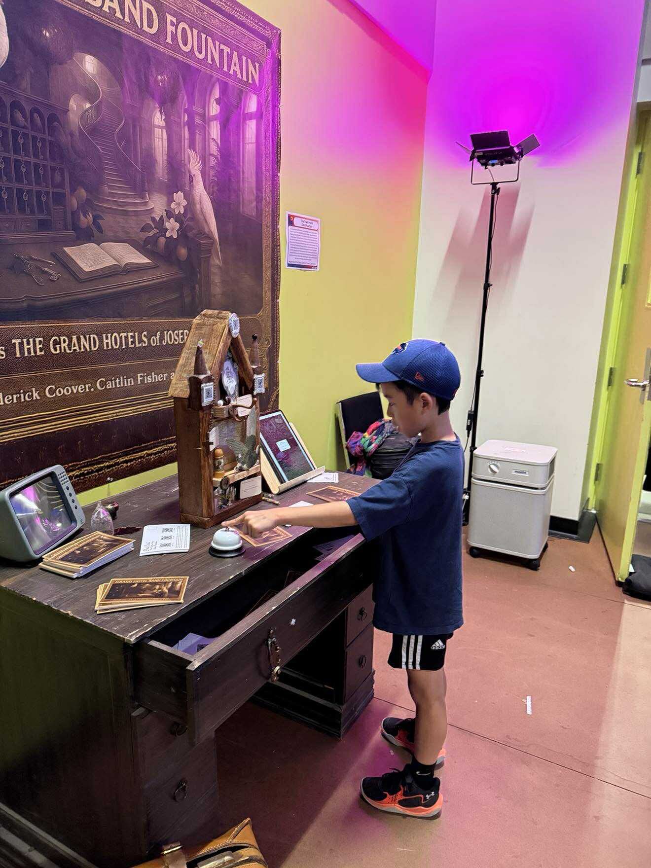 A young visitor interacting with The Grand Hotel Sand Fountain installation at ELO 2025.